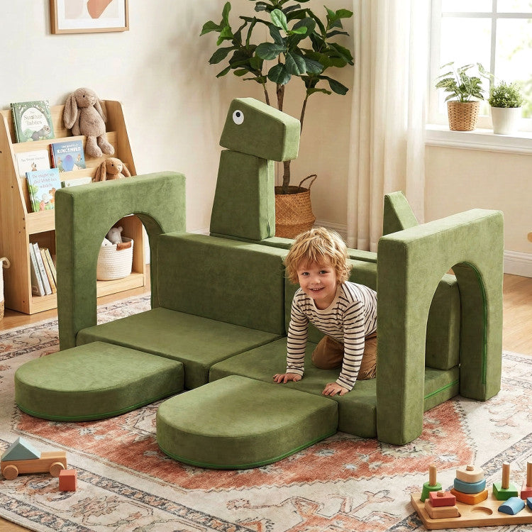 Child playing on a green dinosaur-shaped play couch in a room with books and plants.