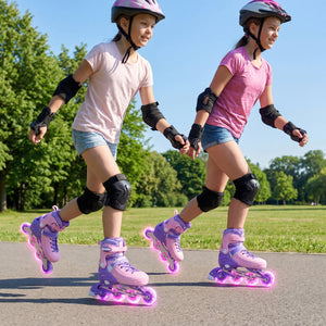 Two children rollerblading outdoors on a sunny day with green trees in the background.