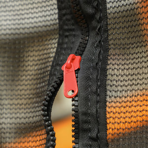 Close-up of a black zipper with a red pull on a textured fabric background