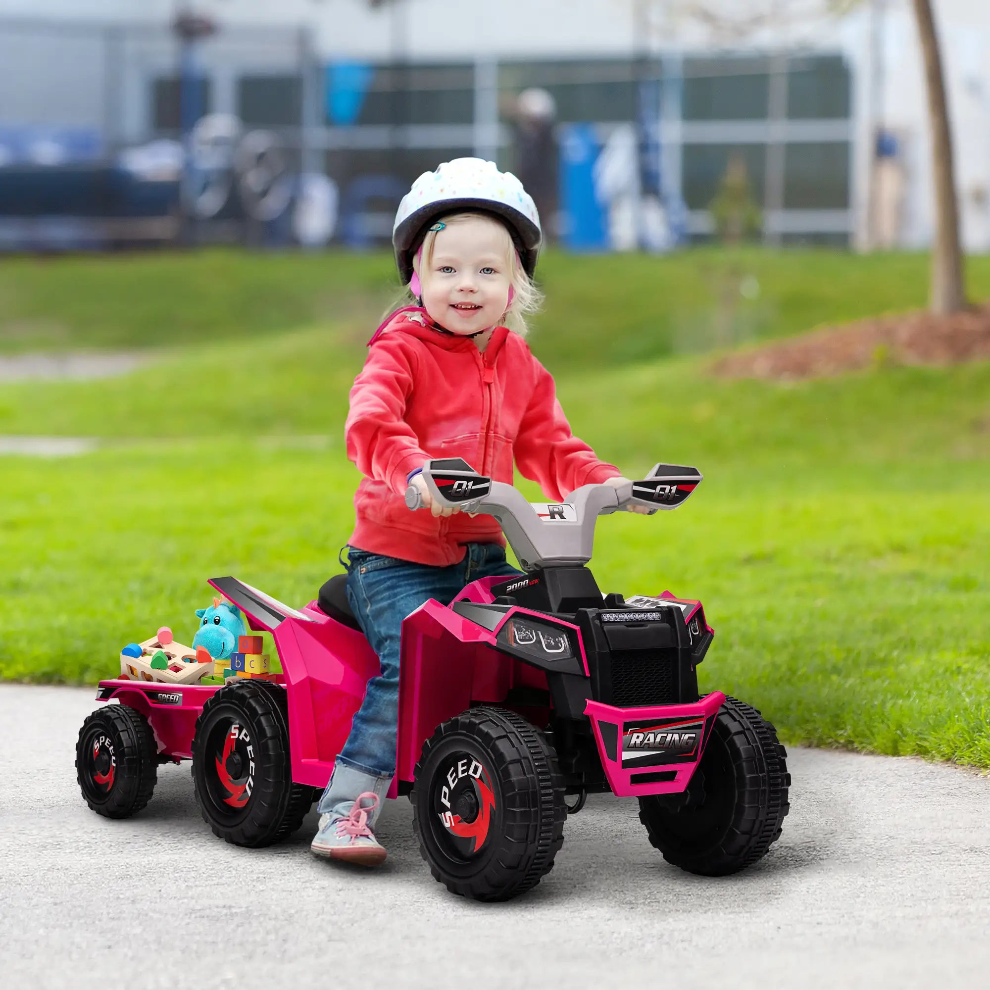 Child riding a pink toy ATV in an outdoor setting