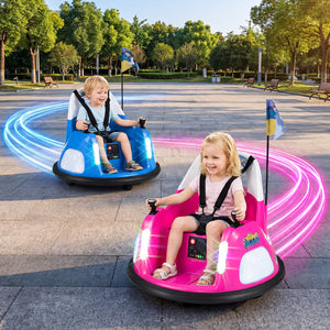 Two children in colorful bumper cars on a paved area with greenery in the background
