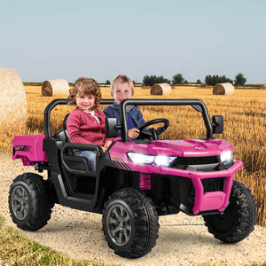 Children sitting in a pink toy off-road vehicle in a field with hay bales.