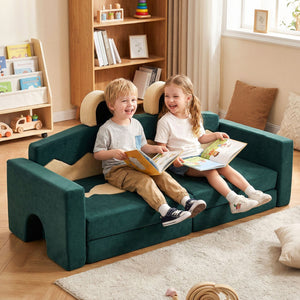 Two children sitting on a green kids' sofa reading books in a cozy living room.