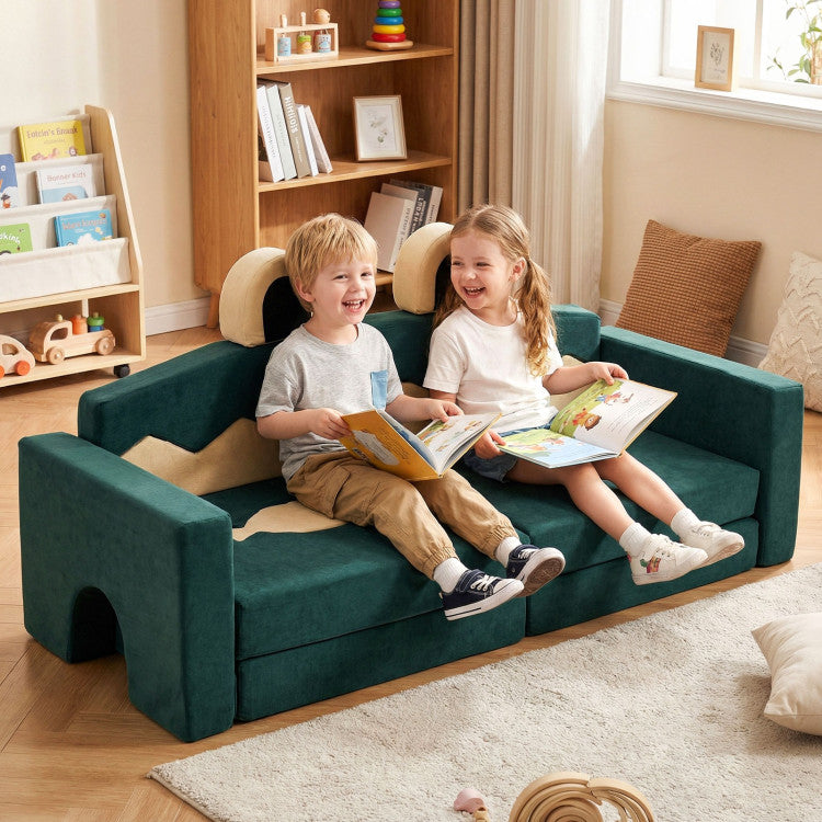 Two children sitting on a green kids' sofa reading books in a cozy living room.