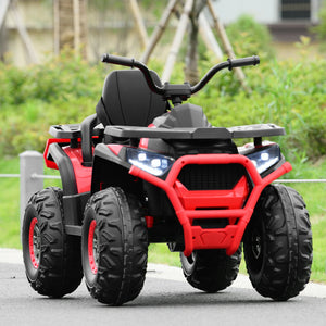 Red and black toy ATV on a paved surface with grass and trees in the background
