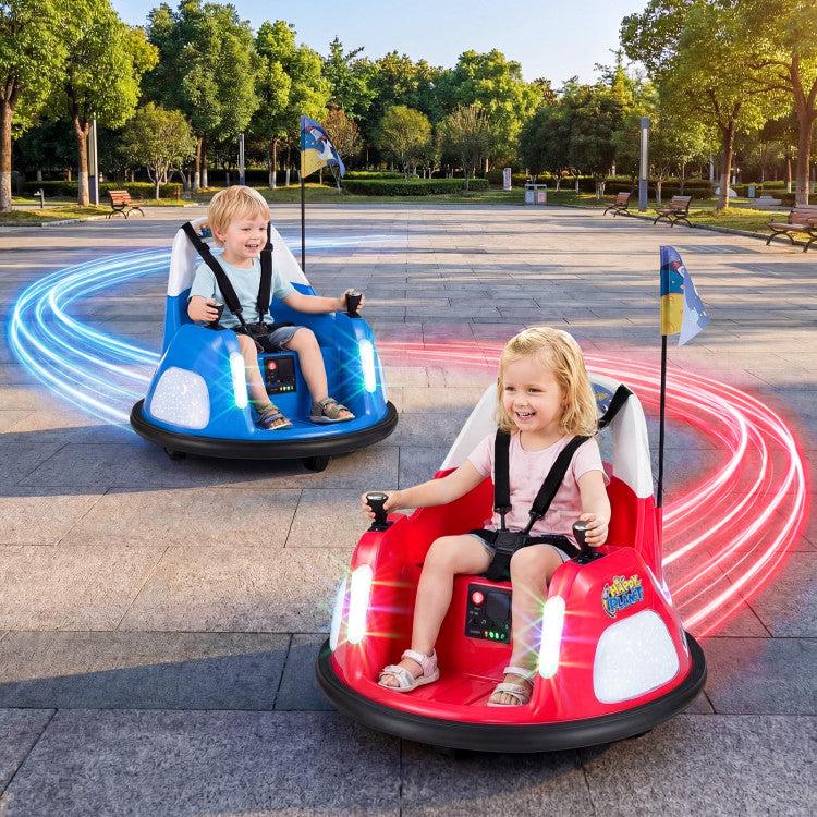 Two children in colorful bumper cars on a paved area with trees in the background