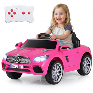 Child sitting in a pink toy car with a remote control on a white background