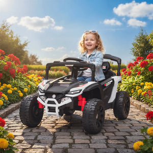 Child sitting in a toy car on a stone path with flowers and trees in the background