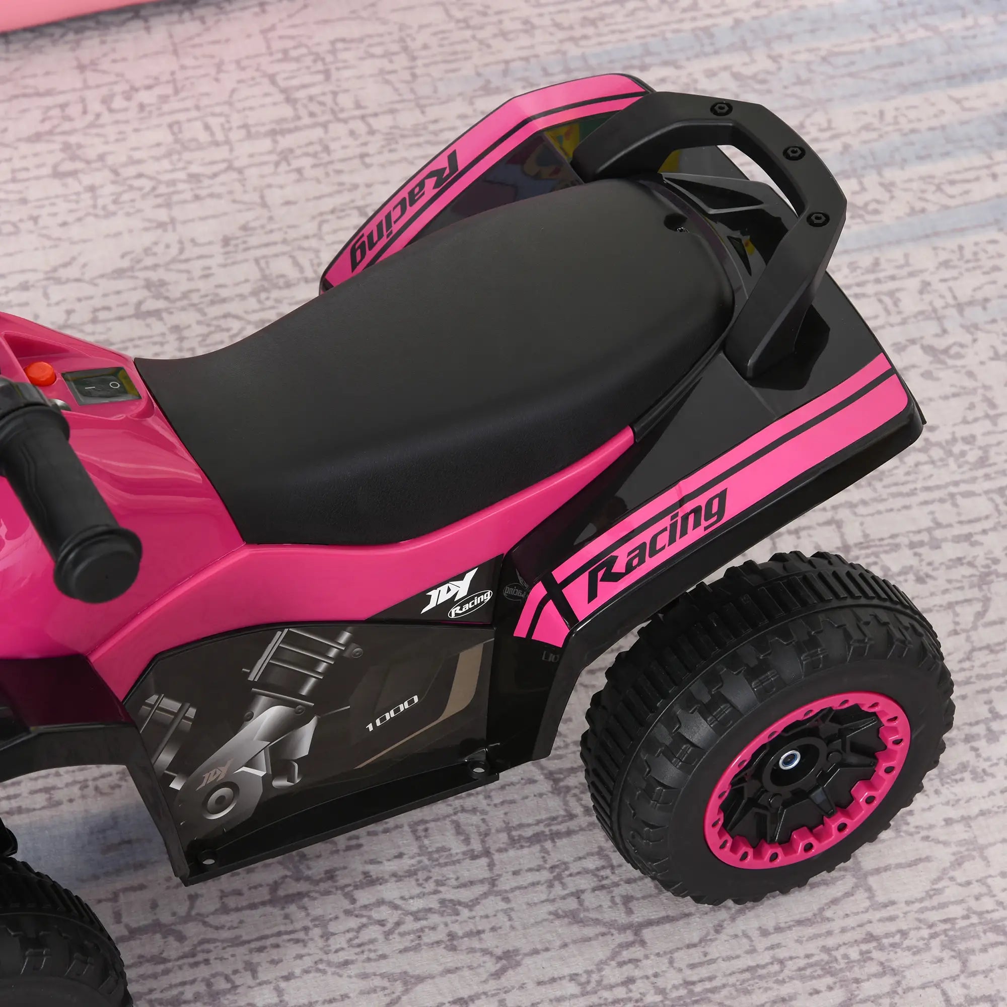 Pink and black toy motorcycle with 'Racing' text on a textured surface