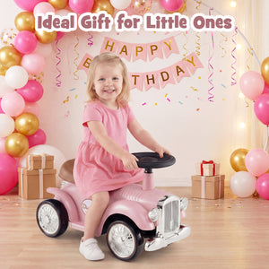 Child in a pink dress riding a toy car with balloons and birthday decorations in the background