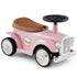 Pink vintage-style toy car with brown seat on a white background