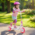 Child riding a scooter in a park with a helmet and protective gear.