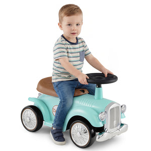 Child sitting on a turquoise toy car with a white background