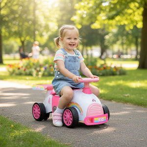 Child sitting in a pink toy car in a park
