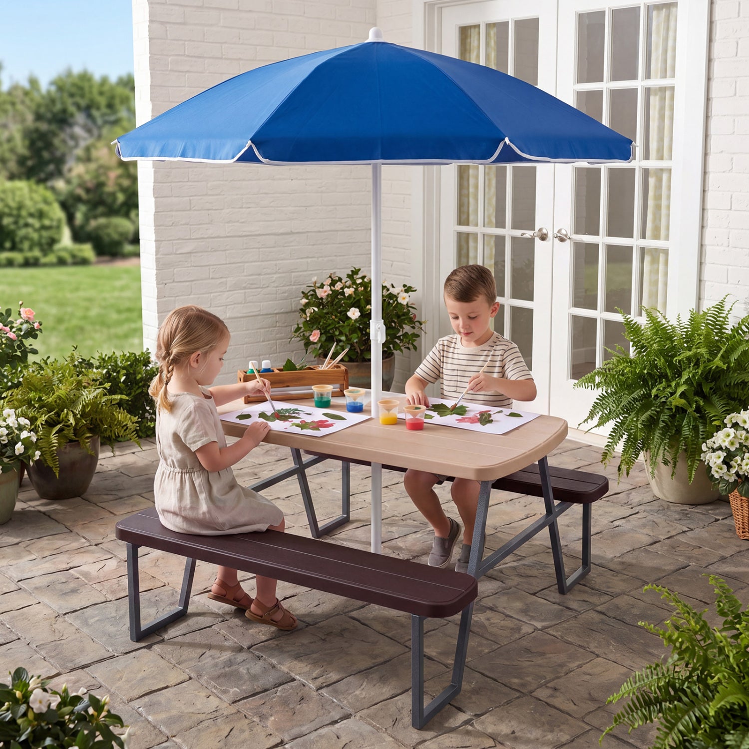 Children sitting at a picnic table with a blue umbrella on a patio