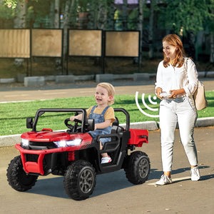 Woman pushing a child in a red toy truck outdoors.
