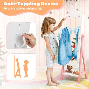 Child standing next to a pink stand with clothes, holding an anti-toppling device.
