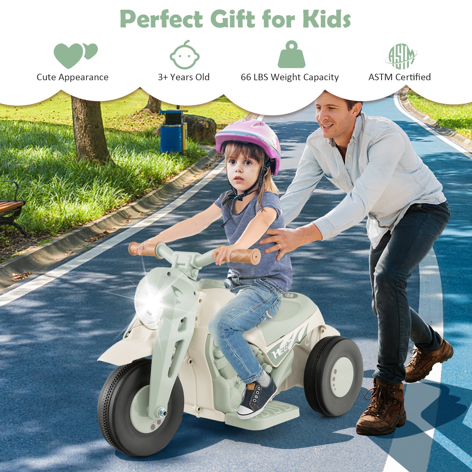 Child riding a toy motorcycle with an adult pushing from behind on a sunny day.