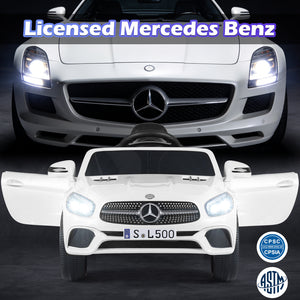 White toy car with Mercedes-Benz logo next to a real Mercedes-Benz car on a dark background.