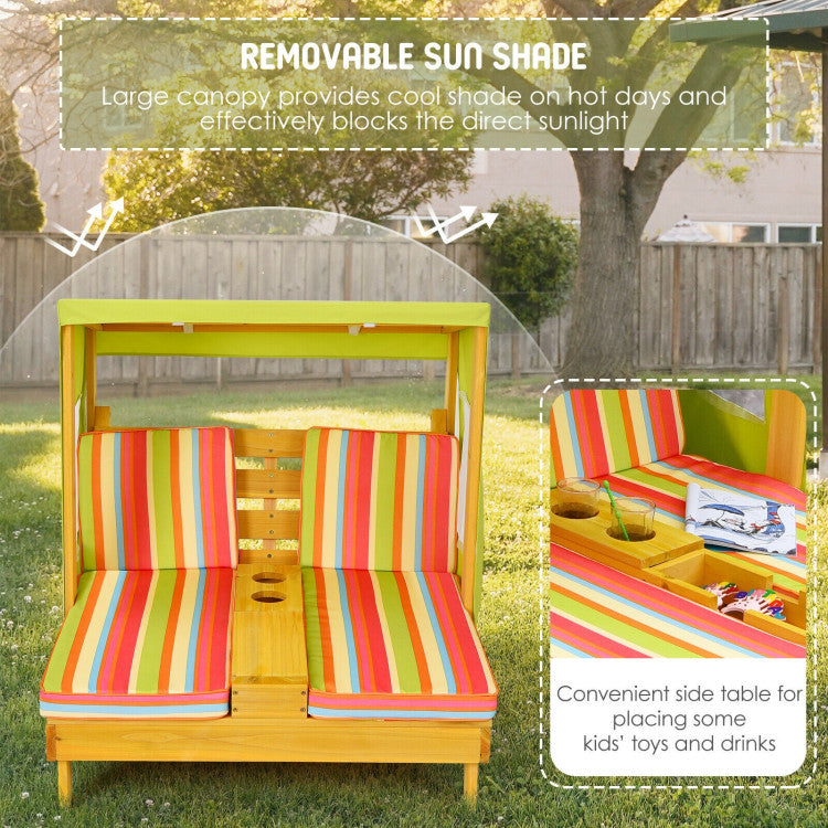 Children's outdoor playhouse with colorful striped cushions and a removable sun shade in a backyard setting.
