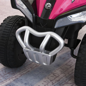 Close-up of a pink and black toy ATV with a silver footrest on a textured surface.