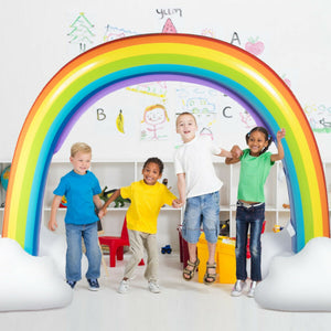 Large inflatable rainbow sprinkler spraying water in backyard