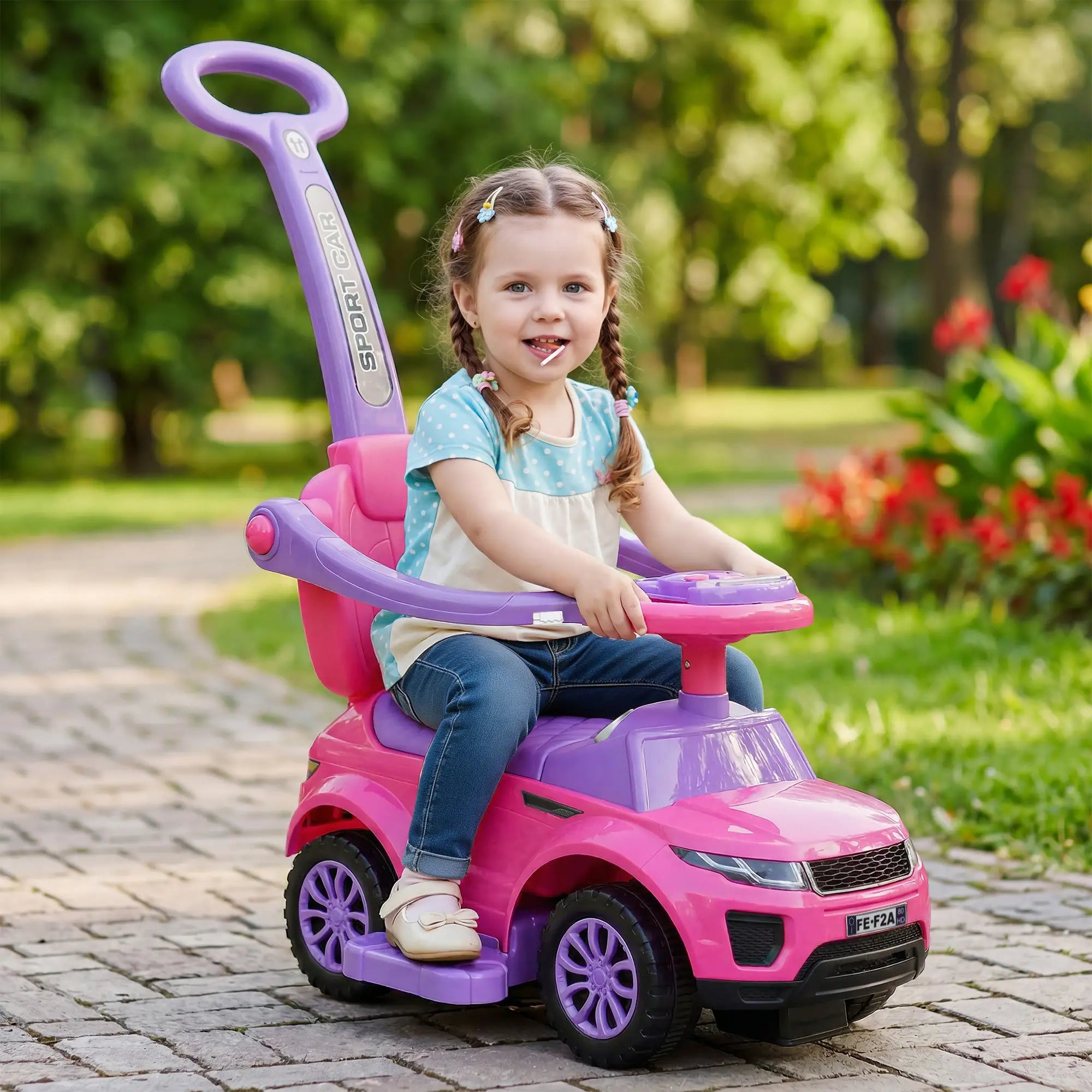 Child sitting in a pink and purple toy car outdoors