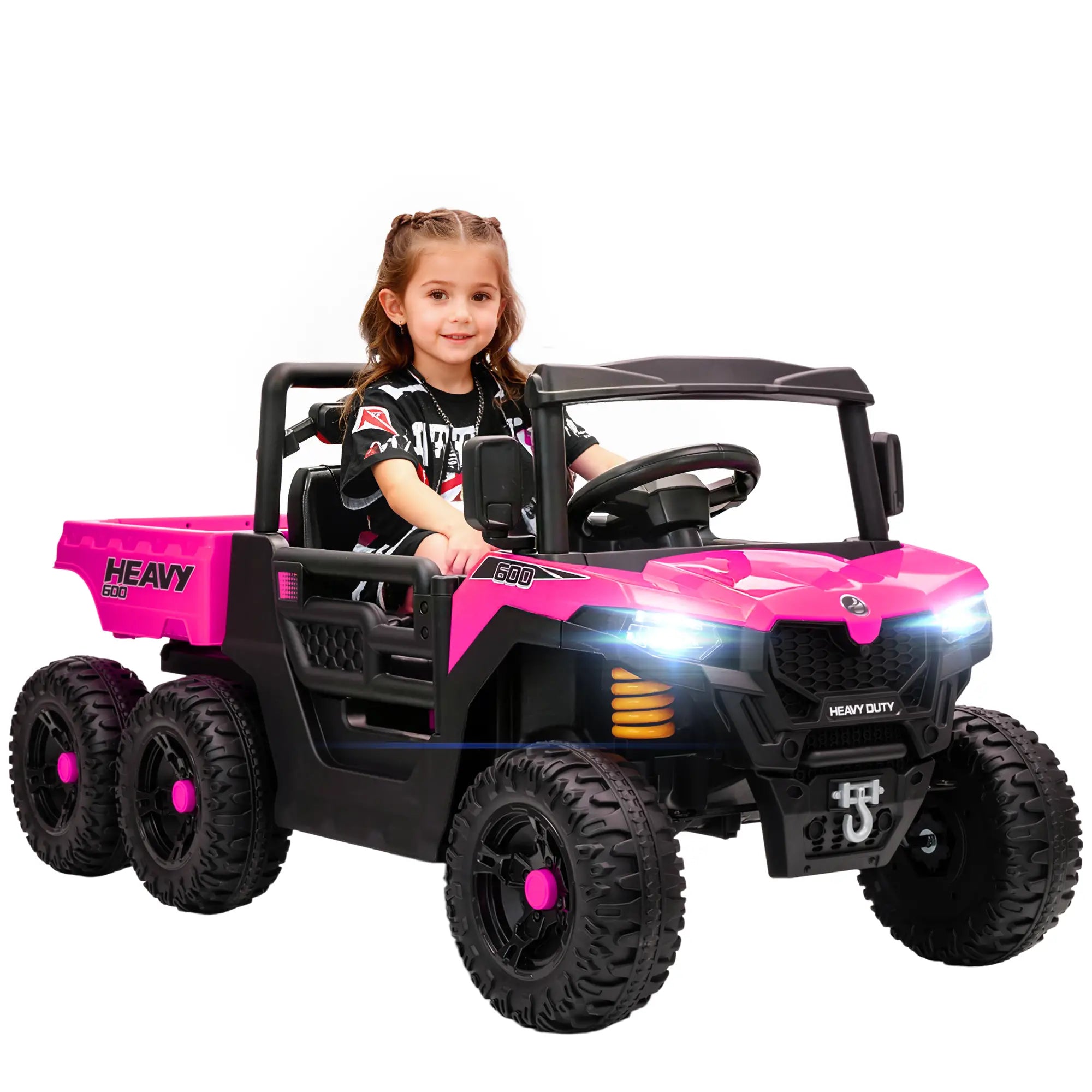 Child sitting in a pink and black toy truck on a white background