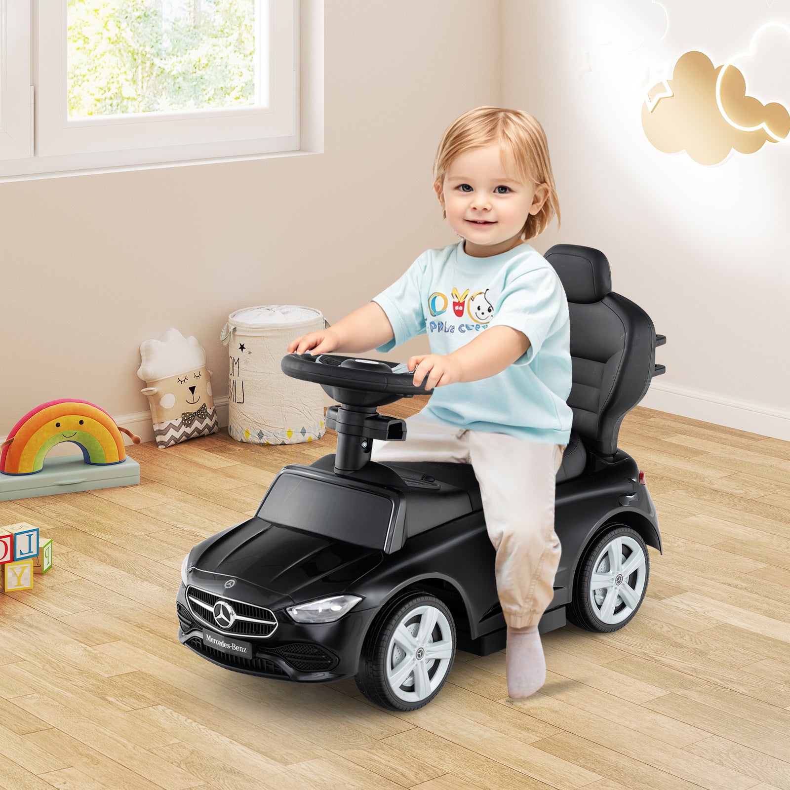 Child playing with a toy car in a room with toys and a window.