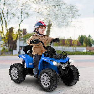 Child riding a blue toy ATV on a paved area with trees and houses in the background