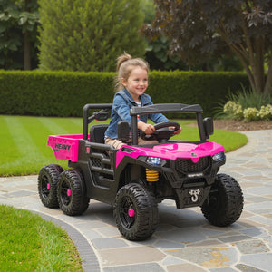 Child playing with a pink and black toy truck on a stone path.