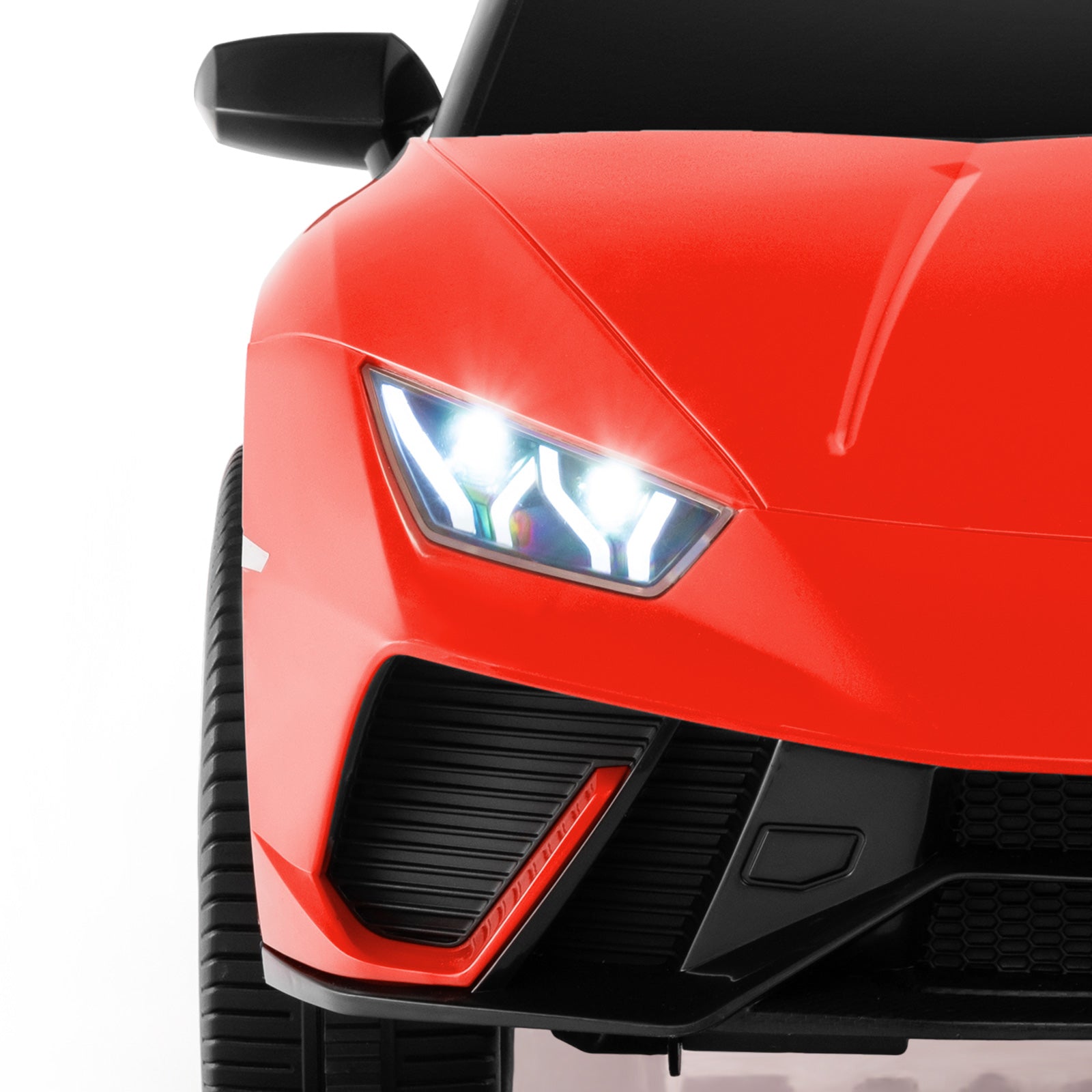 Close-up of a red sports car's front headlight on a white background