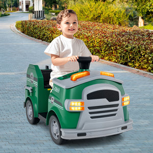 Child playing with a green toy truck on a paved path.