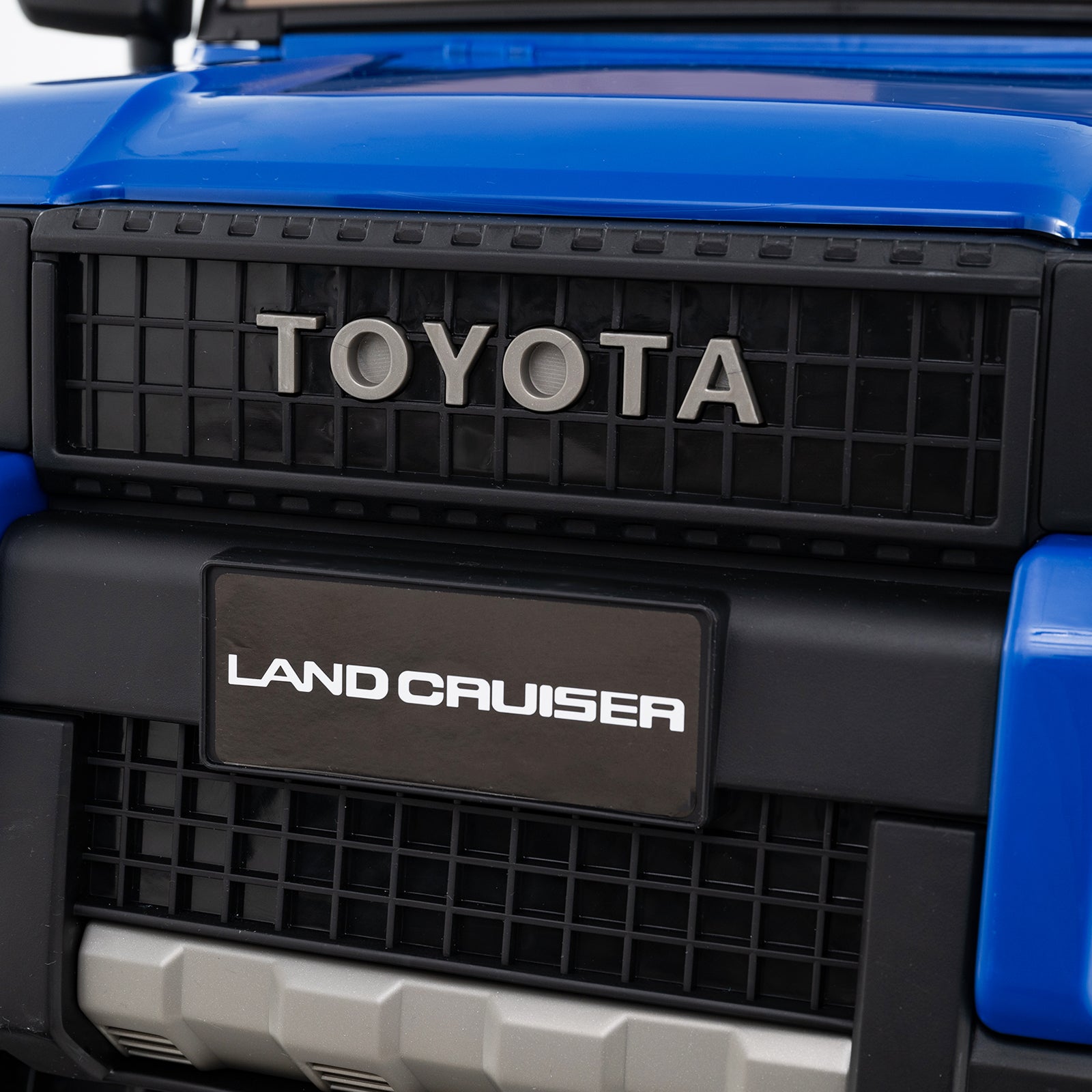 Close-up of a Toyota Land Cruiser grille with 'Toyota' and 'Land Cruiser' branding.