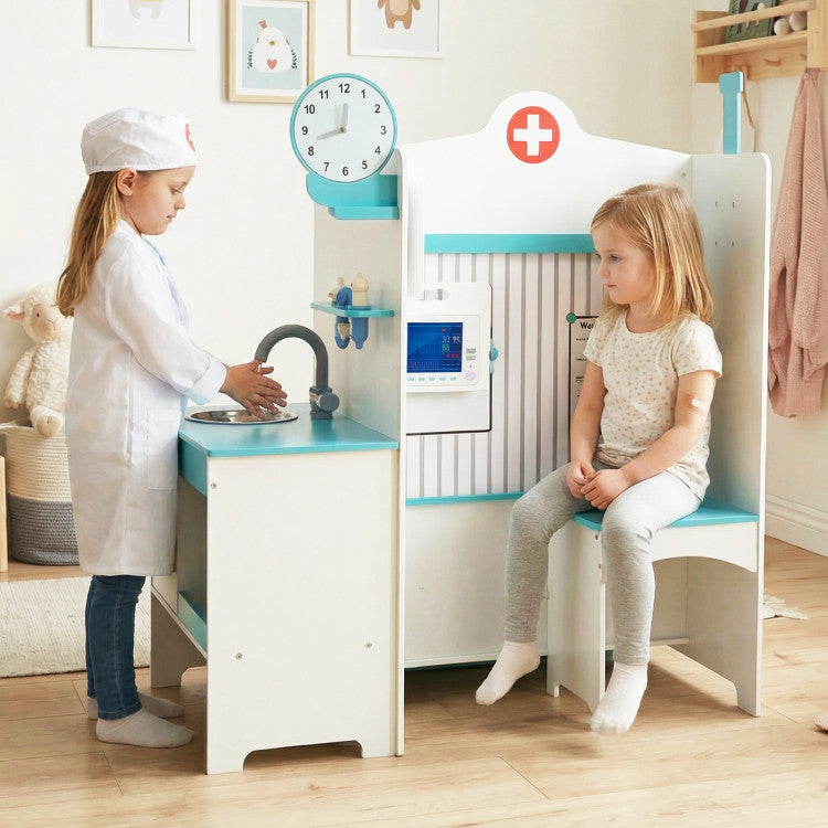 Children playing with a toy kitchen set in a room with a clock on the wall.
