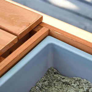 Wooden deck chair with a blue sandpit
