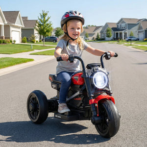 Child riding a red and black toy motorcycle on a suburban street.