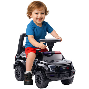 Child sitting in a toy police car on a white background
