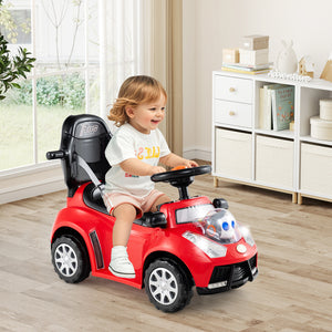 Child sitting in a red toy car indoors with a neutral background