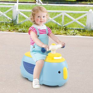 Child sitting on a blue and yellow toy whale in an outdoor setting