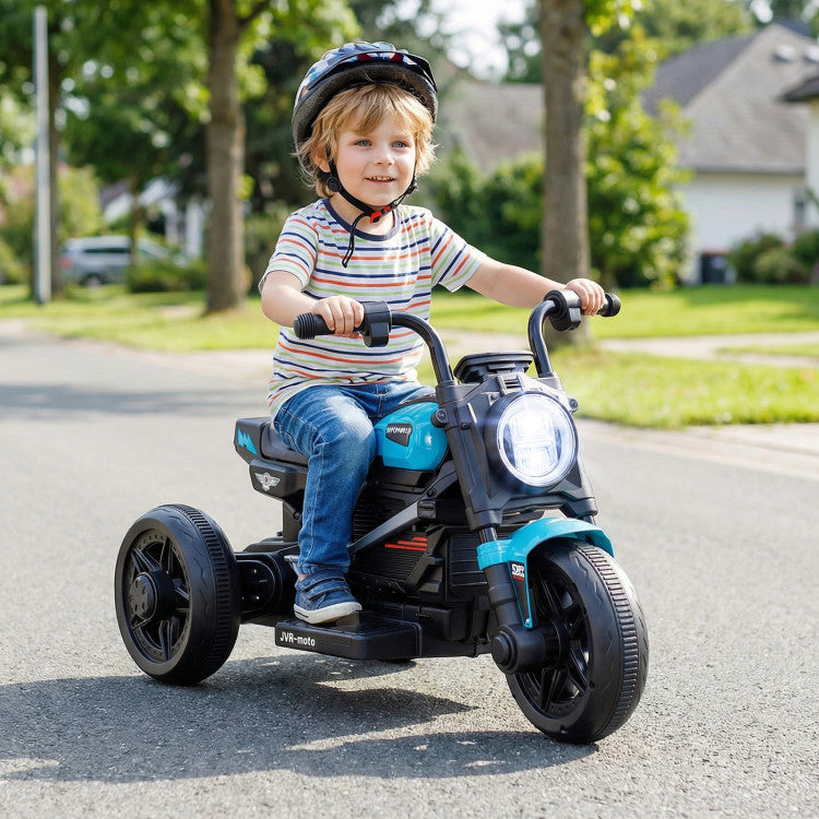 Child riding a toy motorcycle on a street with trees and houses in the background