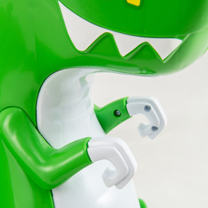 Close-up of a green and white toy figure with a large mouth on a light gray background