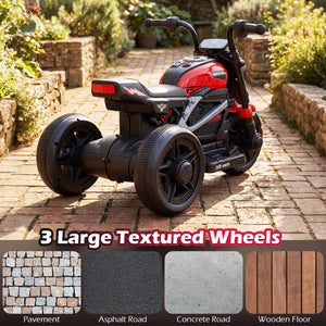 Children's electric trike with large textured wheels on a brick path, surrounded by greenery.