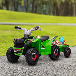 Green toy ATV with a trailer carrying toys on a gravel path with grass and trees in the background