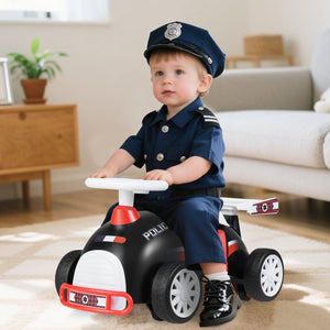 Child in a police uniform sitting on a toy police car in a living room.