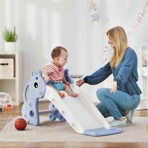 Baby playing on a blue and white slide with a woman in a home setting.
