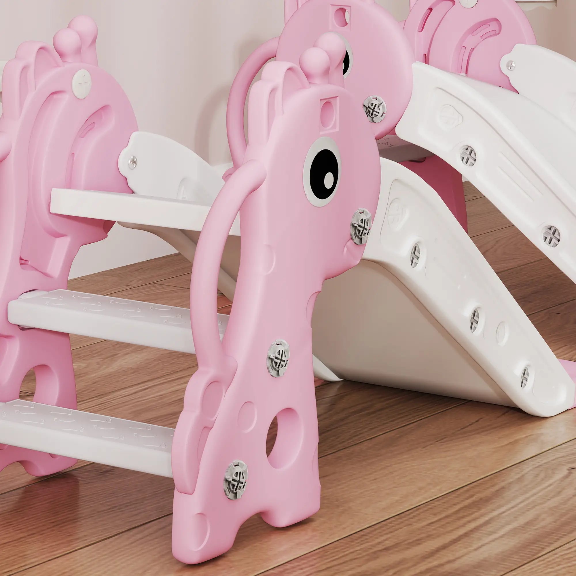 Pink children's slide with a cartoon face on a wooden floor