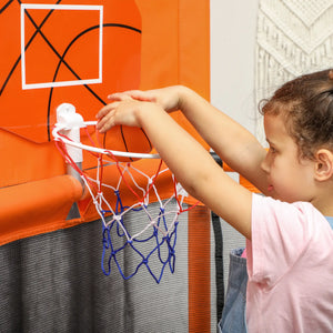 Child playing with a basketball hoop attached to a wall.