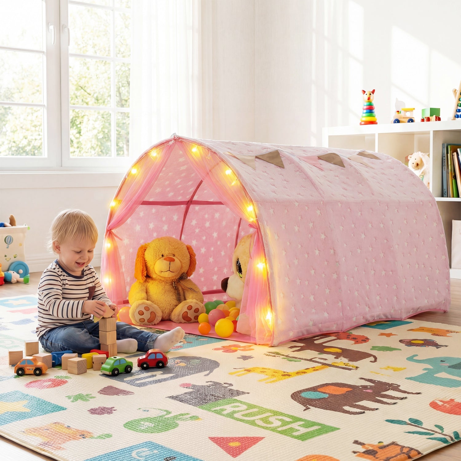 Child playing with a pink play tent in a room with toys and a rug.
