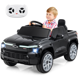 Child playing with a toy truck and remote control on a white background